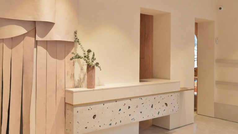 Diseño de interior minimalista en tonos cálidos con paredes de revestimiento natural marmorino, transformando el espacio en un ambiente elegante y saludable